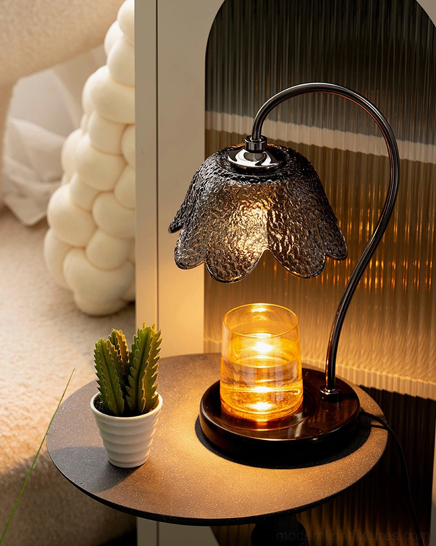 Bedroom ambient lighting with candle warmer lamp on night table with lit candle and cactus decor