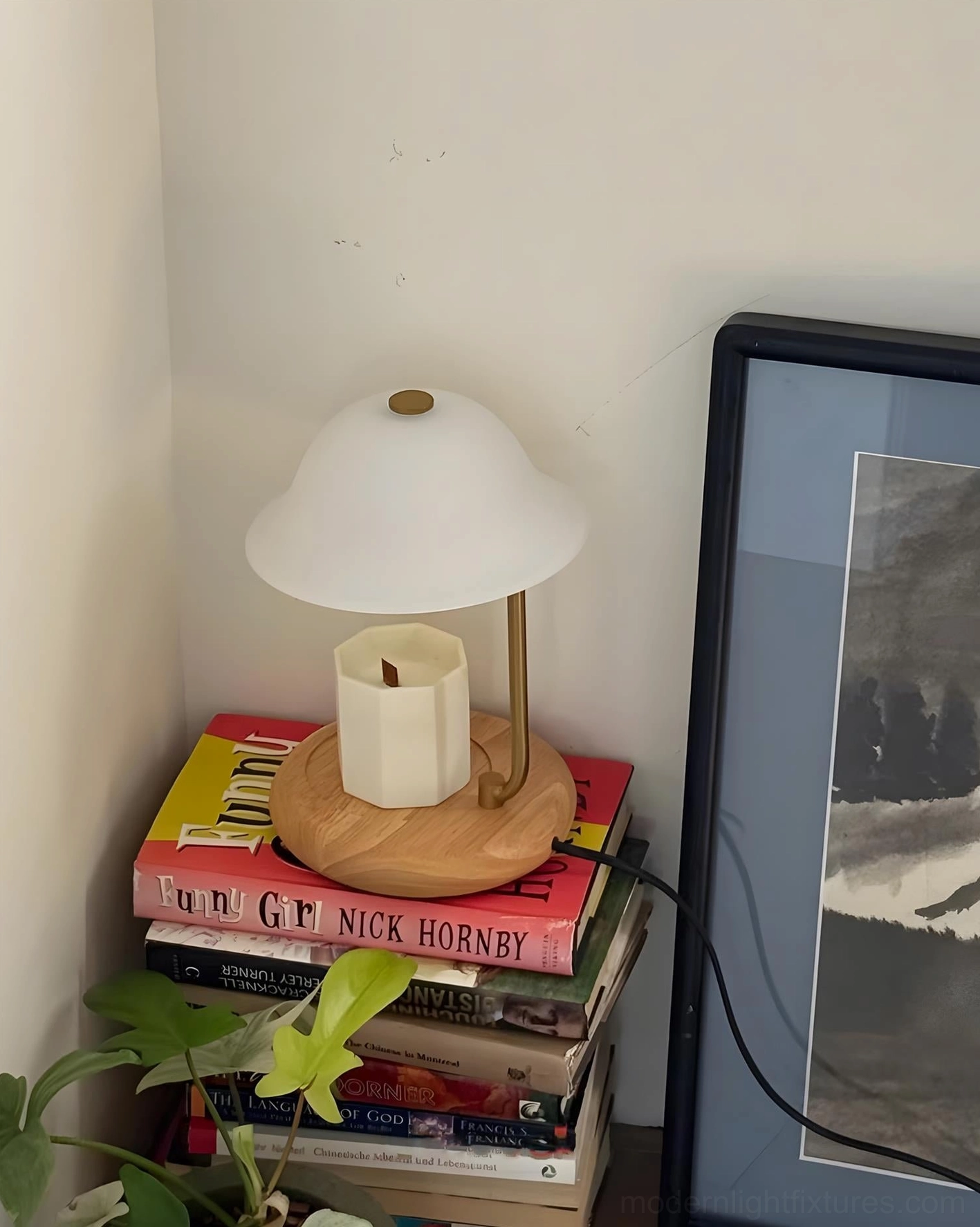Contemporary candle warmer table lamp close-up showing curved metal stem, white shade, and natural wood construction