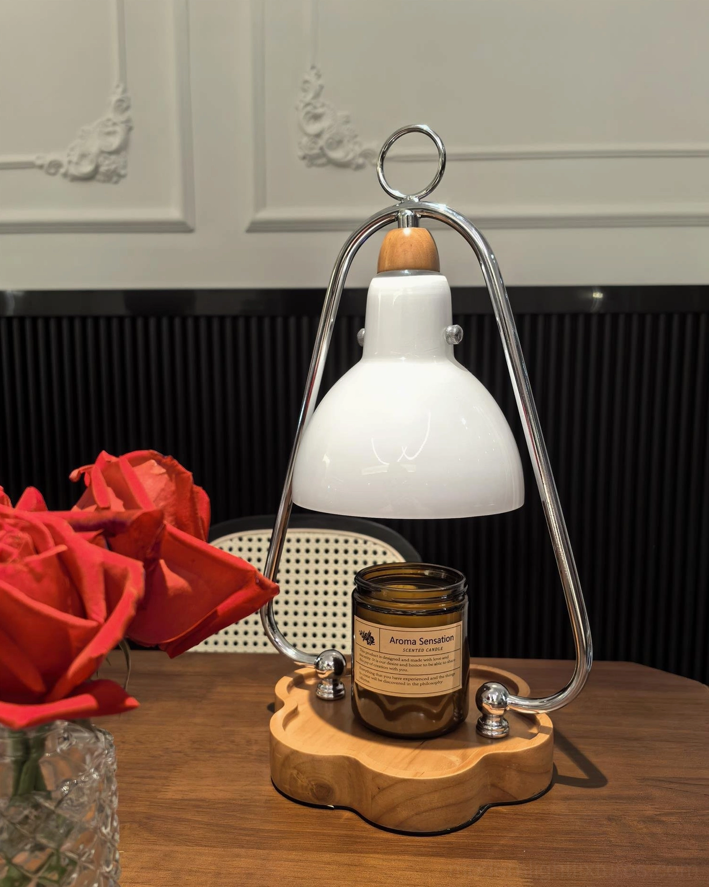 Contemporary candle warmer lamp beside red roses creating romantic table setting