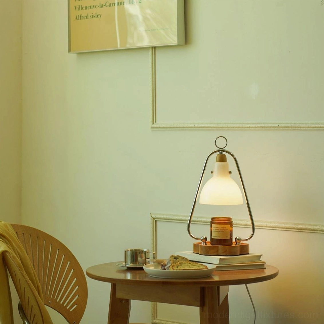 Contemporary candle warmer lamp displayed on wooden side table in warm home interior setting with books