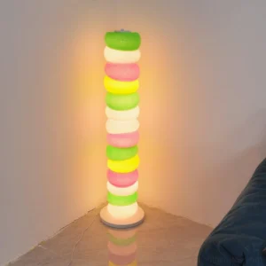 Illuminated colorful glass ring floor lamp glowing in cozy living room corner with warm white LED lighting