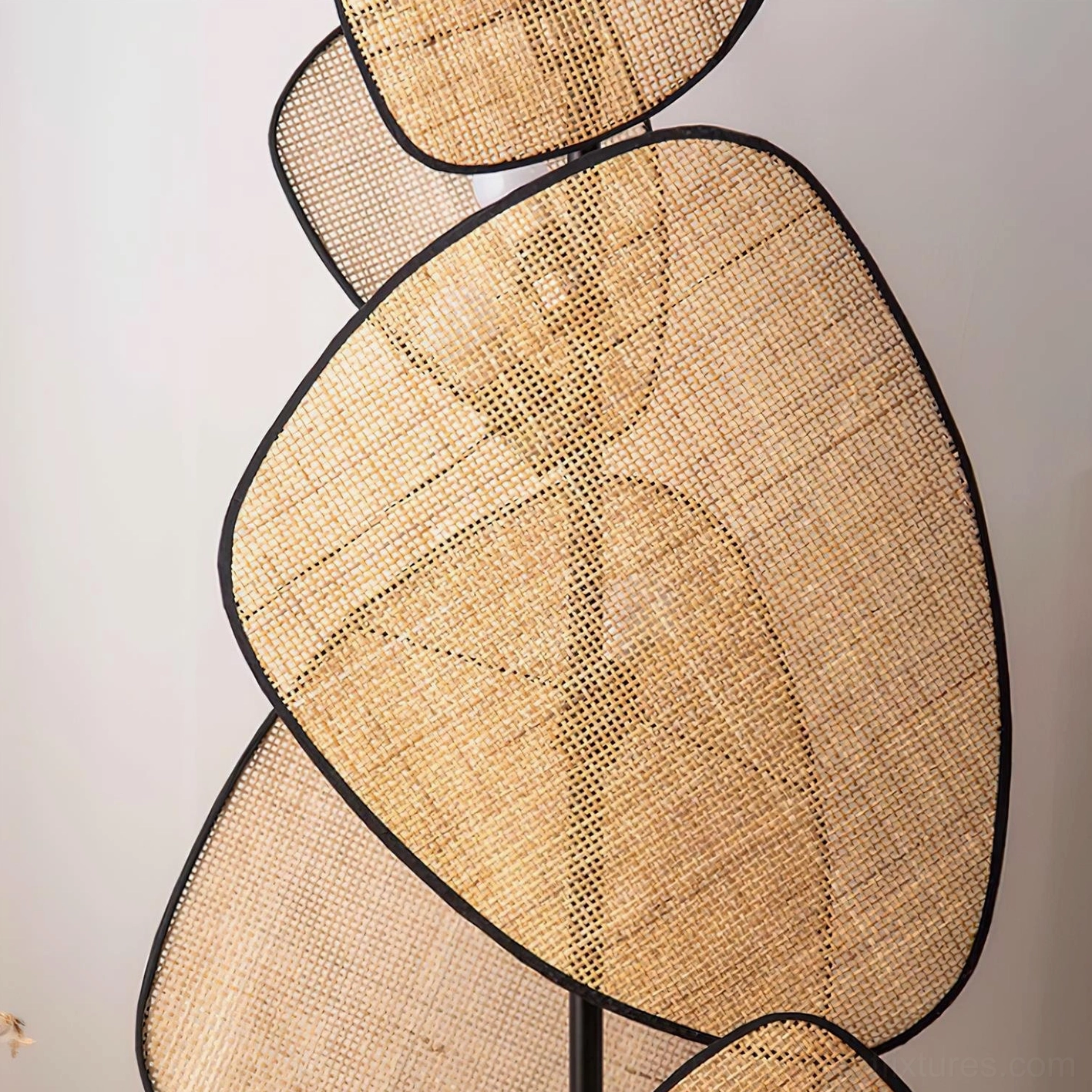 Close-up detail of cannage floor lamp's hand-woven rattan shade texture with black metal edging