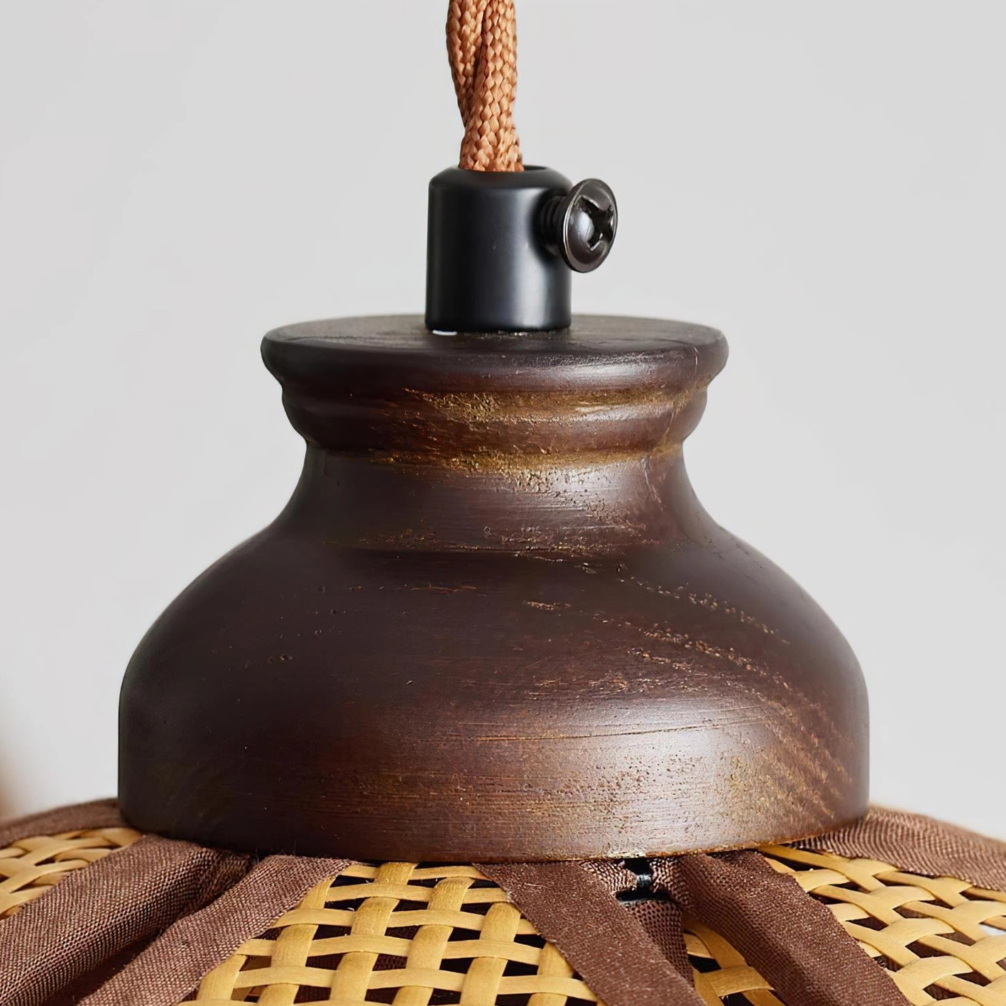 Capelina pendant lamp in natural rattan color with dark walnut finish hardware in home setting