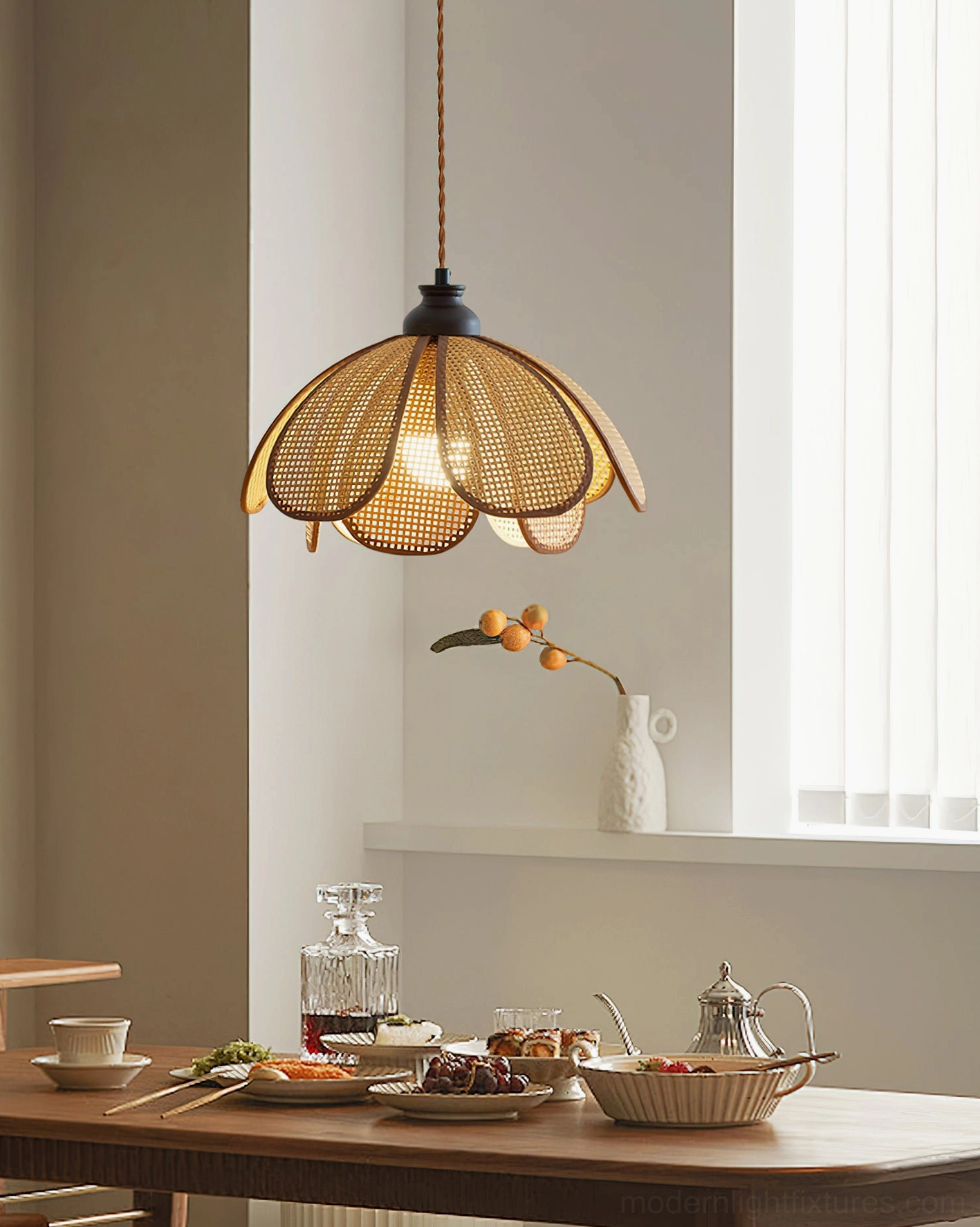 Rattan woven petal pendant lamp Capelina installed above dining table with bohemian home decor styling