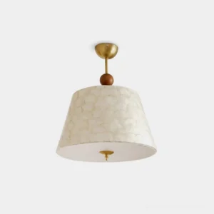 Capella modern ceiling pendant light with brass gold finish, walnut wood accent bead, and off-white textured fabric shade - front studio view