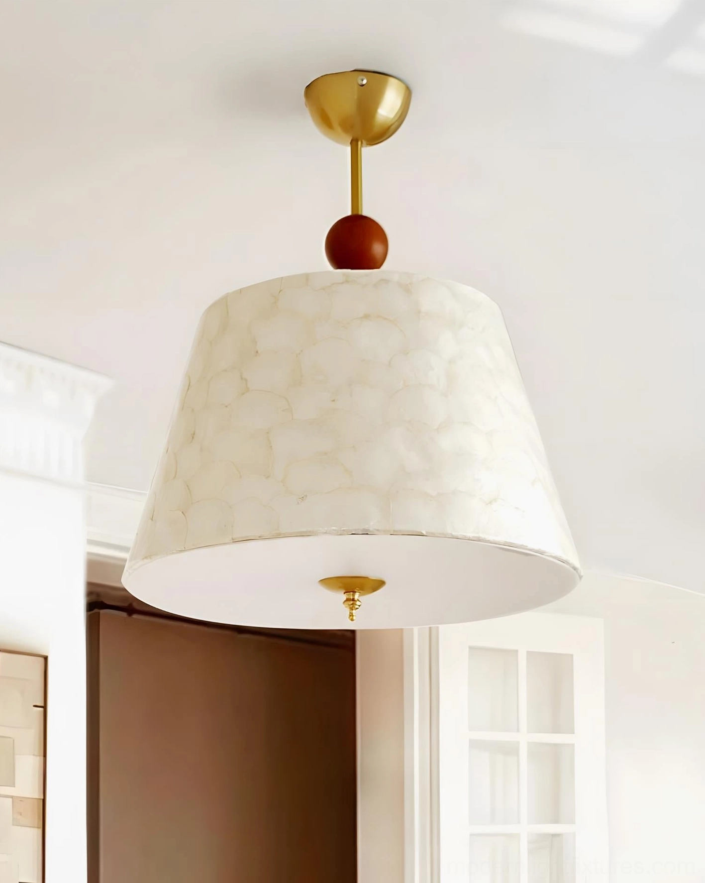 Textured ceiling pendant light with brass finish, wooden accent bead, patterned off-white shade in residential interior