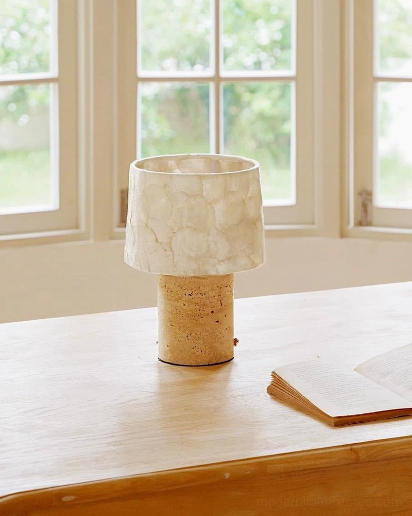 Warm white capiz shell diffusion illuminating from travertine stone table lamp