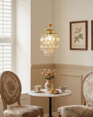 Capiz shell pendant light installed in French style dining room above wooden table with upholstered seating, warm ambient glow through translucent shell petals