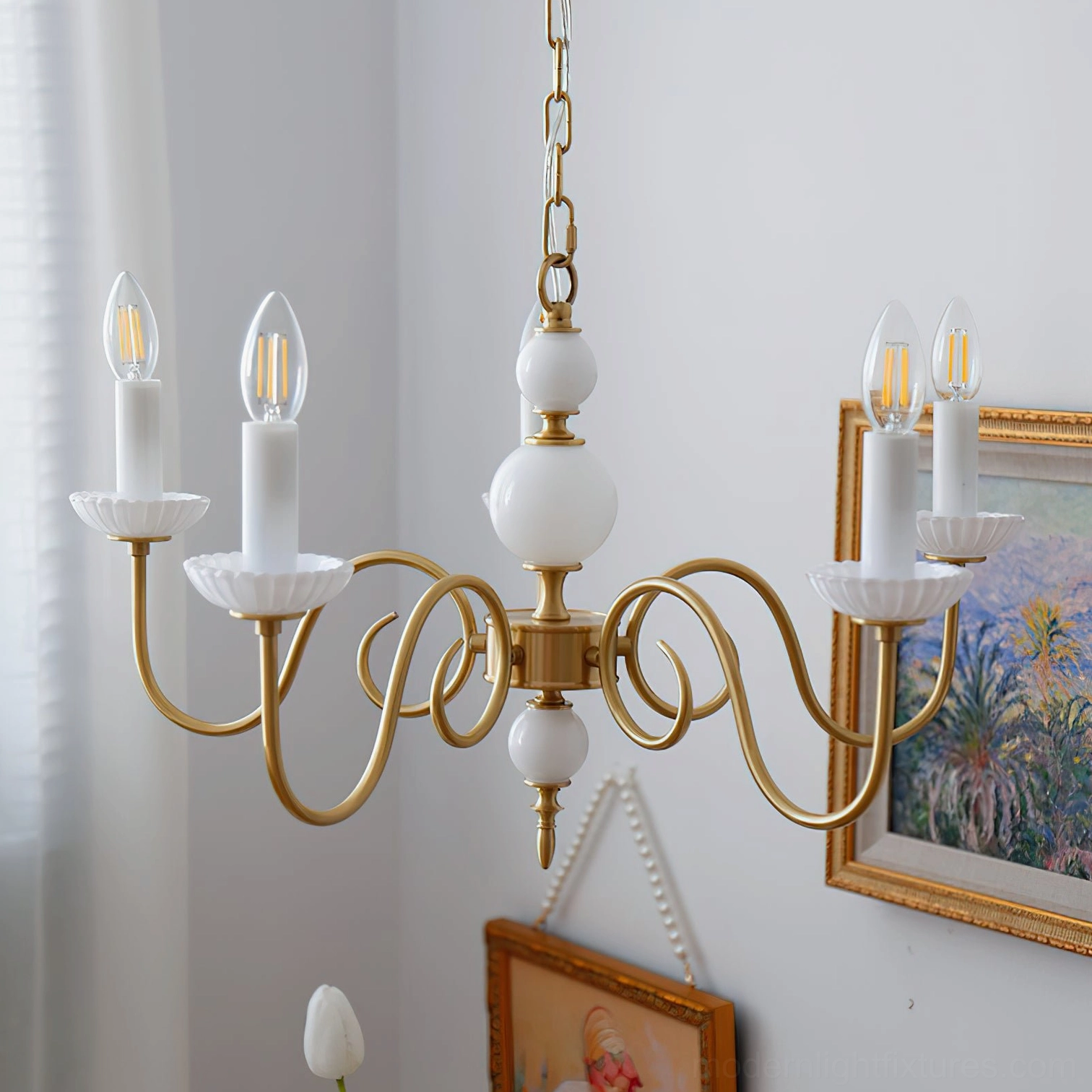 Gold finish brass candle chandelier with white candle-style bulb cups architectural detail