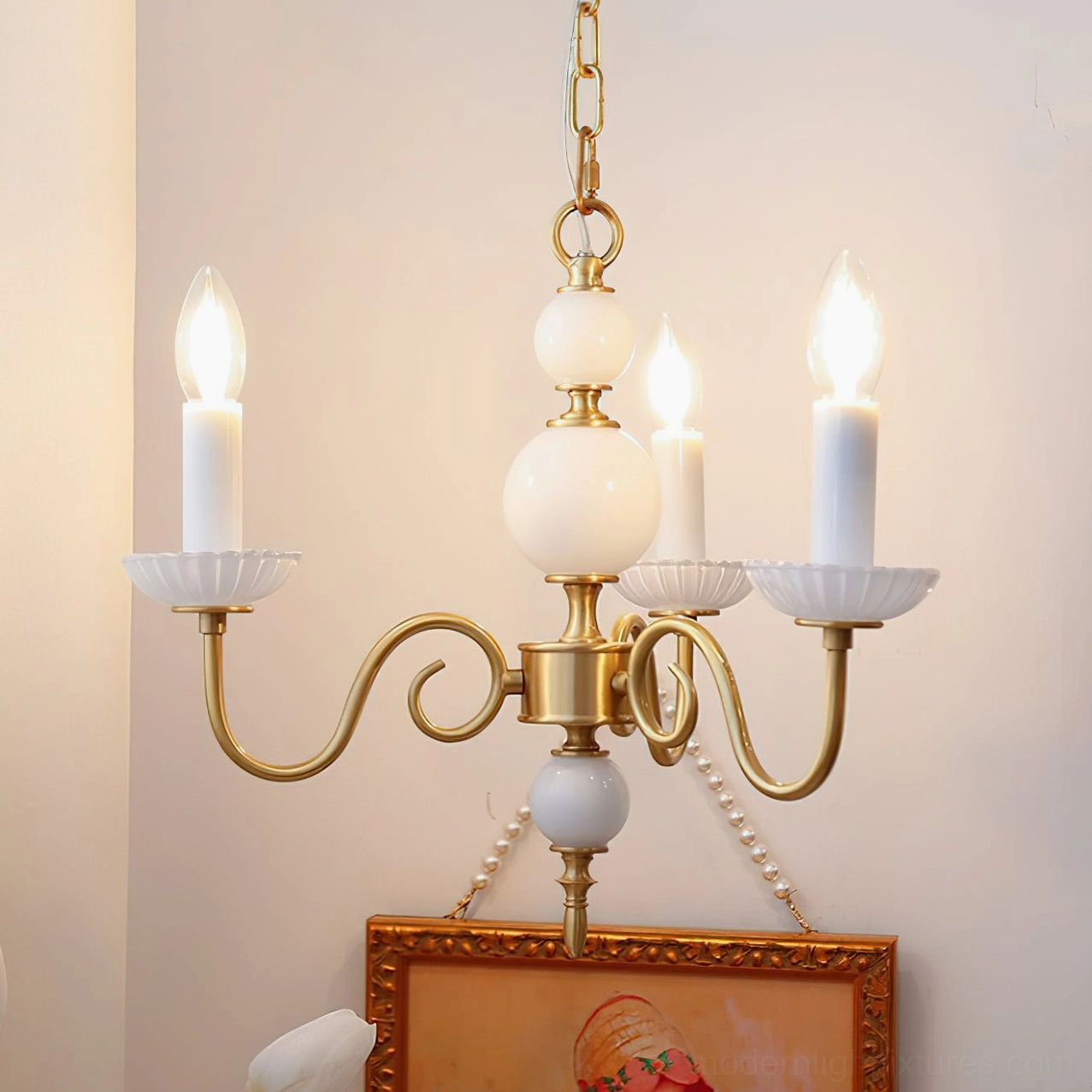 Close-up view of brass chandelier with multiple white spherical decorative elements