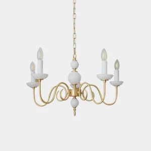 Carlita brass candle chandelier with curved gold arms and white ceramic candle cups on plain background