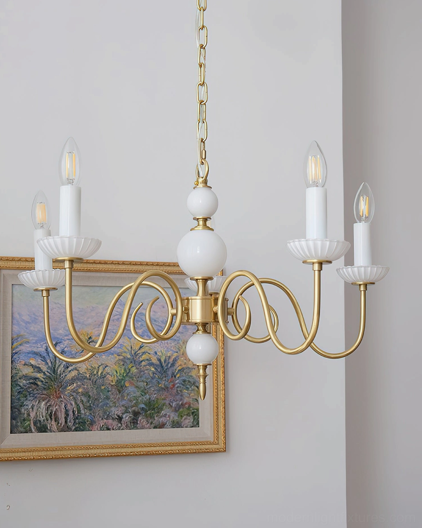 Brass and white ceramic chandelier fixture showing curved arm design and structure