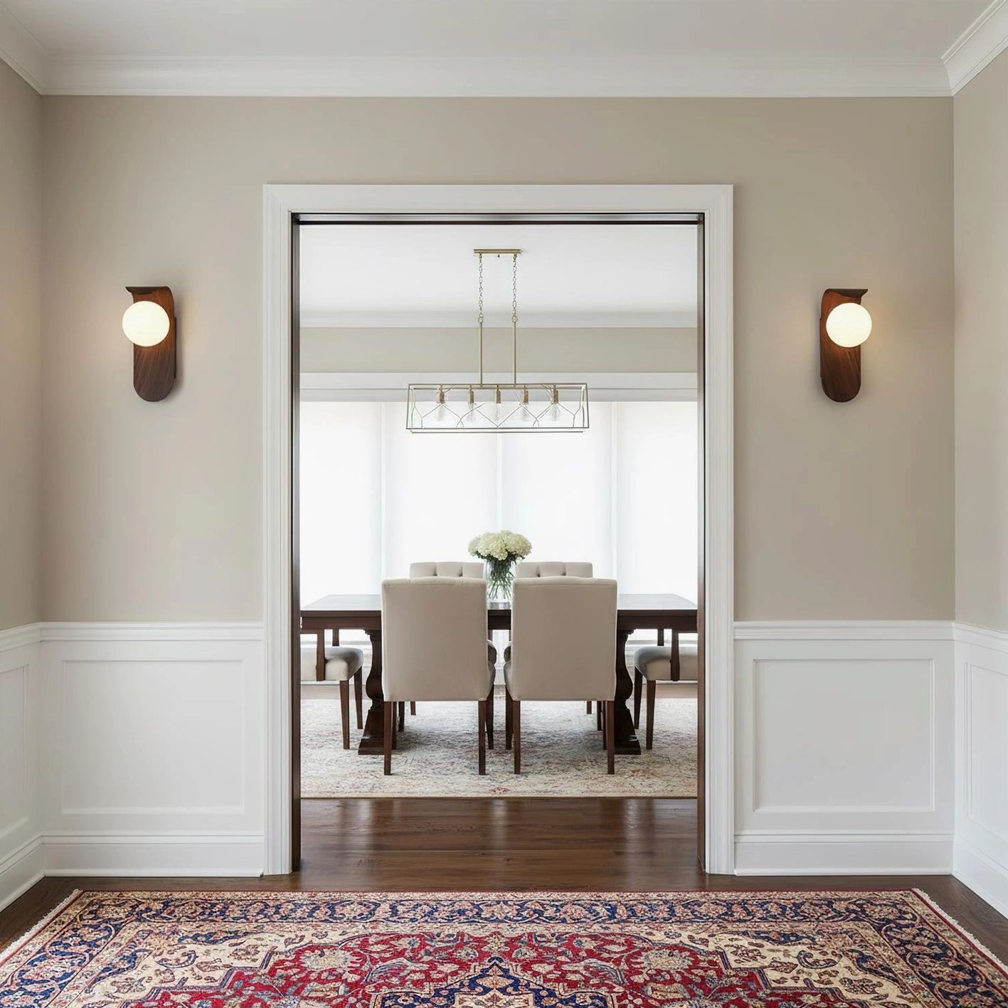 Matching pair of Carlyle wood-tone wall sconces installed symmetrically in formal dining room entryway