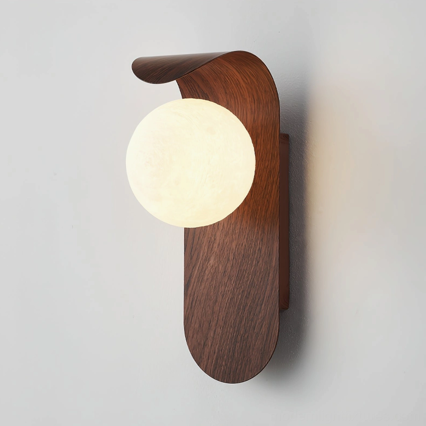 Carlyle wood-tone wall sconce architectural detail showing curved metal arm and glass globe configuration