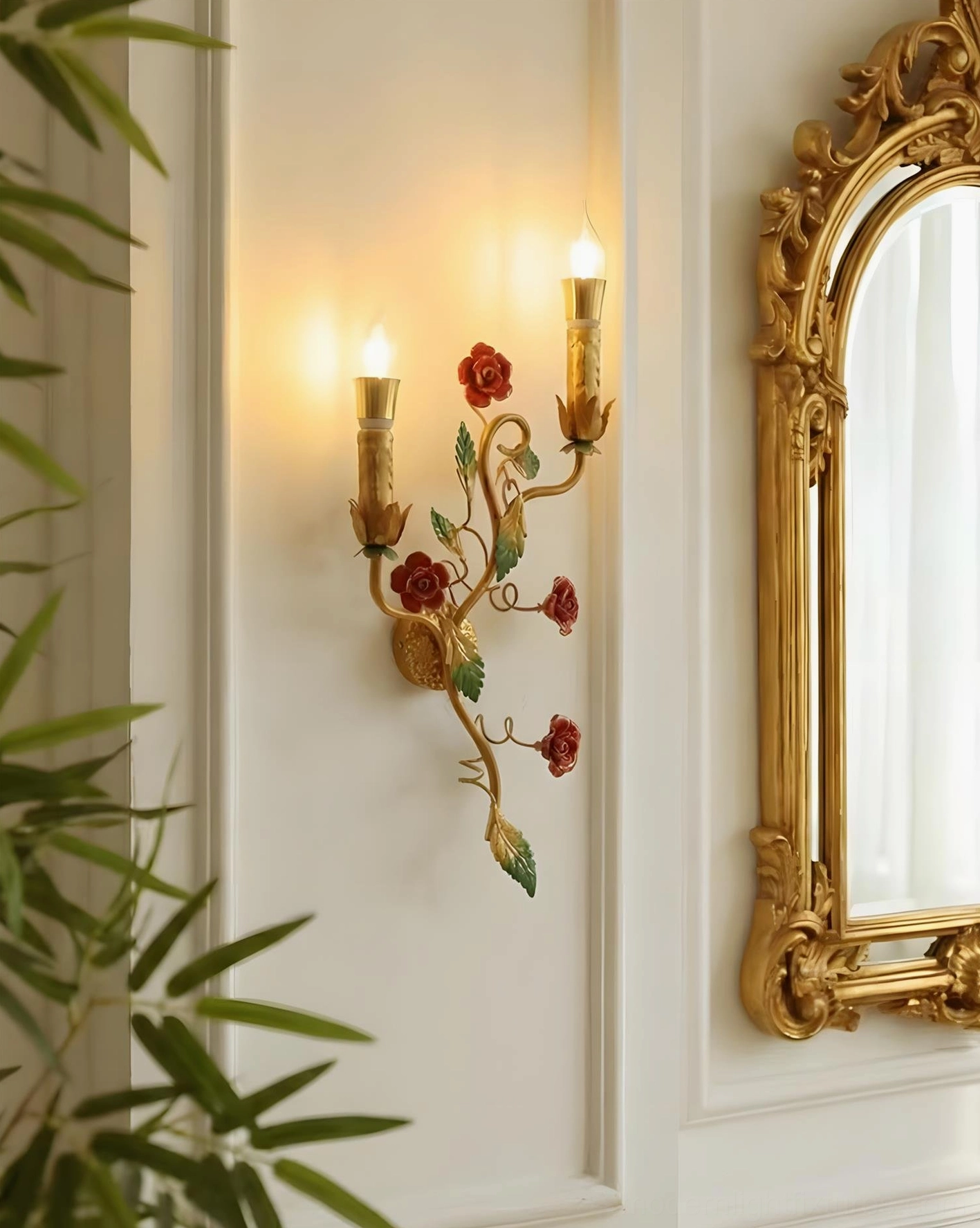 Close-up of Carmelia sconce with hand-painted roses and green leaf details against ornate gold mirror backdrop