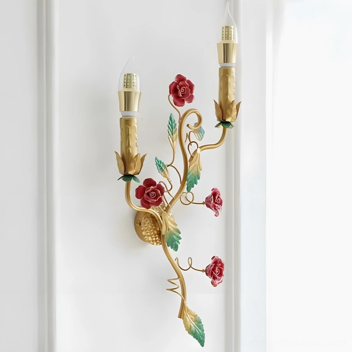 Carmelia floral wall lamp featuring dual candles with gold finished frame and botanical accents, studio product shot