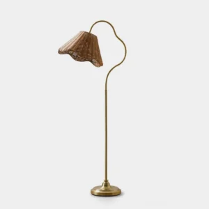 Carmelle hand-woven rattan arc floor lamp with gold-tone metal stem and scalloped shade on white studio background