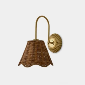Carmelle hand-woven rattan wall sconce with warm gold arm and fluted sunburst backplate, front view studio shot