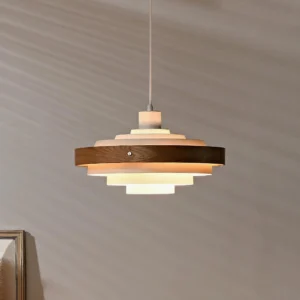 Layered wood and metal pendant lamp with warm interior glow, white and natural wood colorway hanging in interior setting