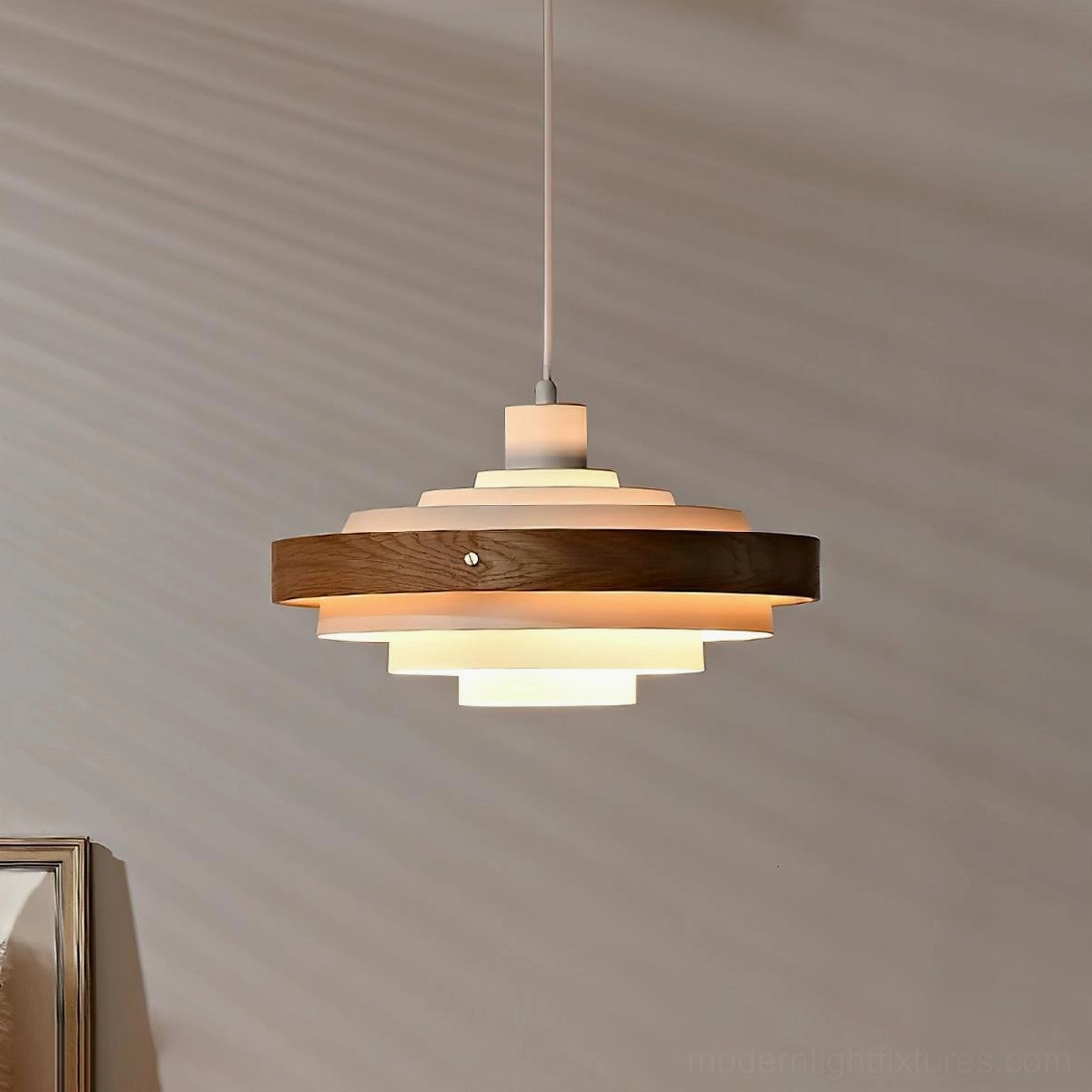 Layered wood and metal pendant lamp with warm interior glow, white and natural wood colorway hanging in interior setting