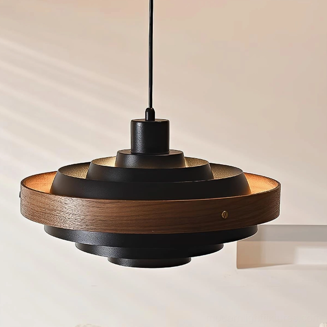 Black metal and walnut wood tiered pendant lamp, close-up front view showing geometric disc layering and warm studio lighting