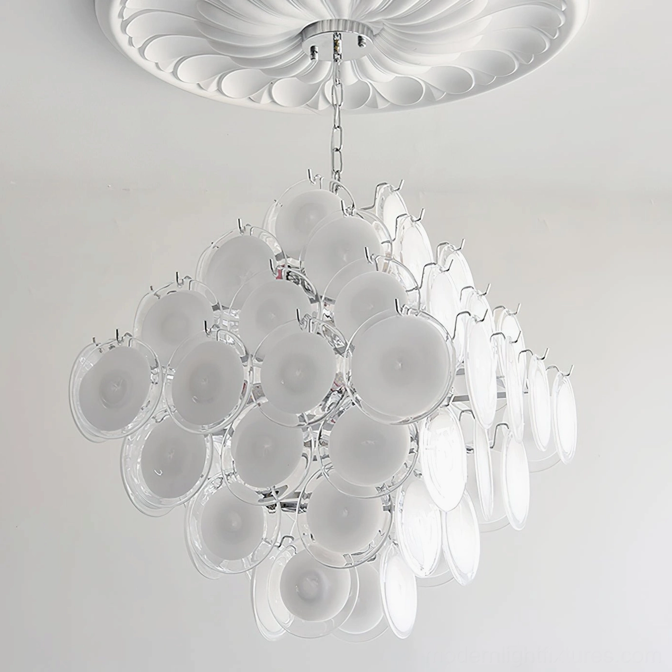 Carmosa glass disc chandelier illuminated evening view demonstrating ambient glow in contemporary space