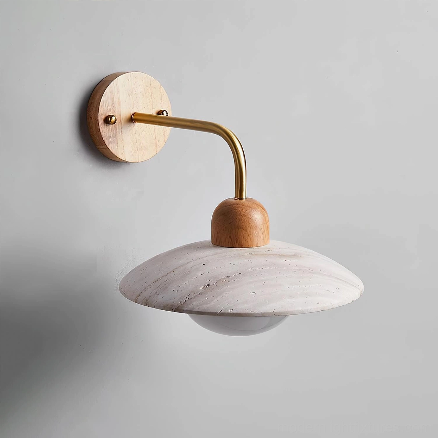Black finish Carolia wall sconce creating graphic contemporary contrast with travertine stone glow