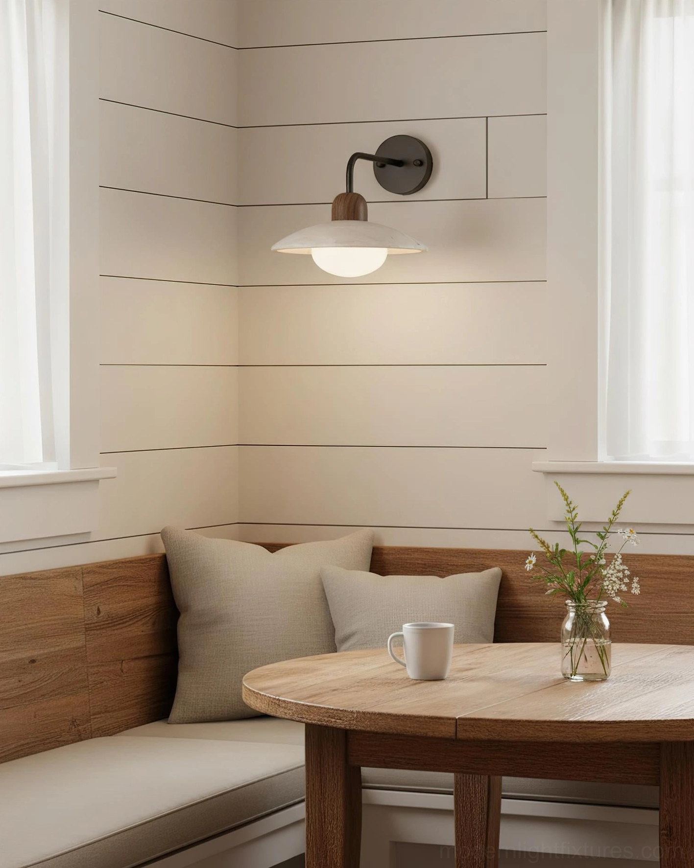 Dining booth wall sconce with matte travertine saucer shade and warm ambient lighting for dining area