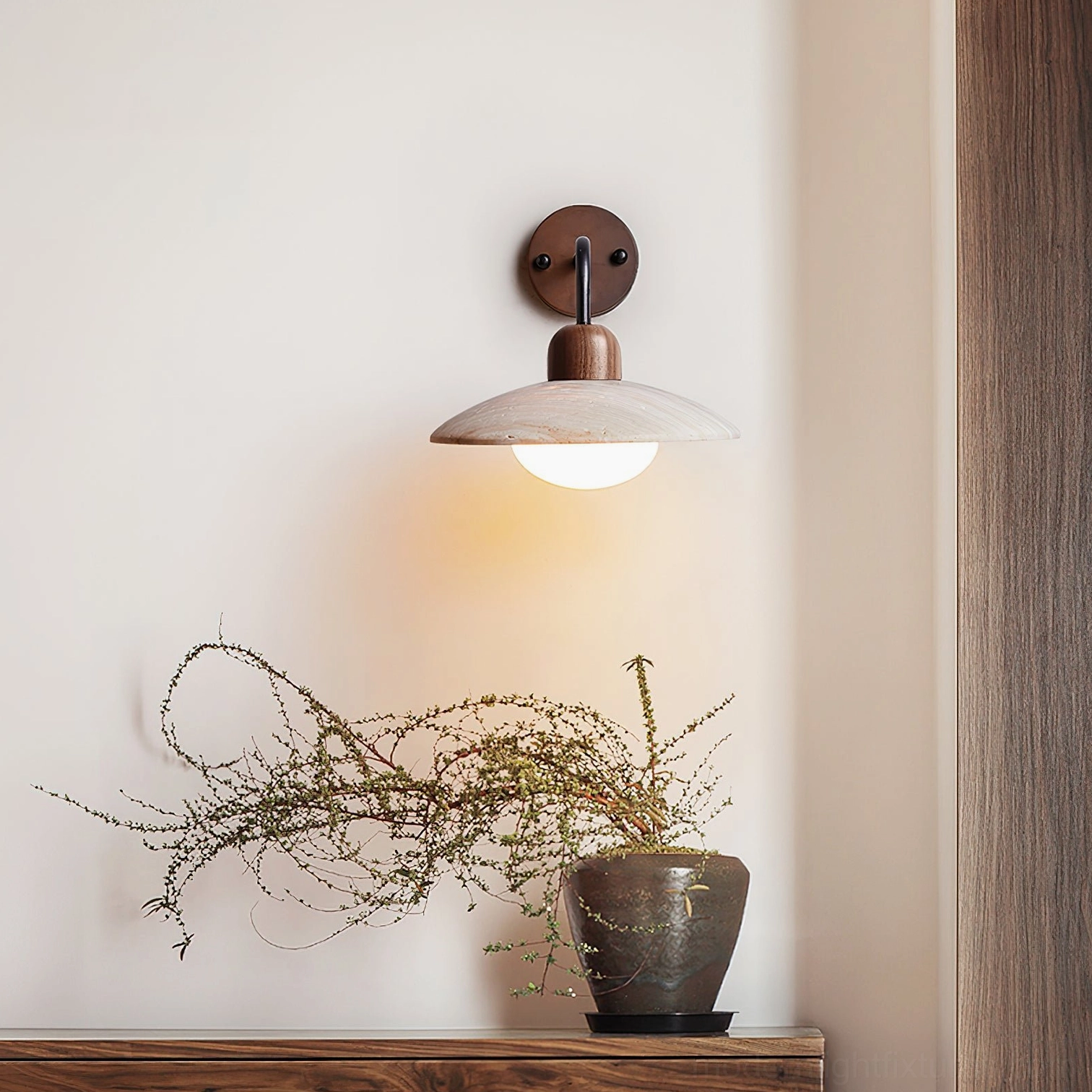 Travertine wall sconce illuminating covered porch outdoor area with damp-rated durability in twilight setting