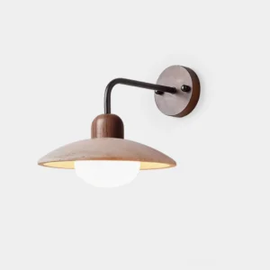 Carolia travertine wall sconce with black metal arm and dark wood base, front view in minimalist studio setting