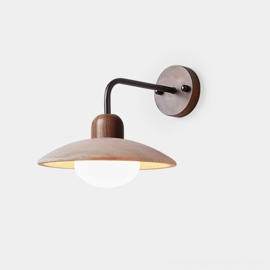 Carolia travertine wall sconce with black metal arm and dark wood base, front view in minimalist studio setting