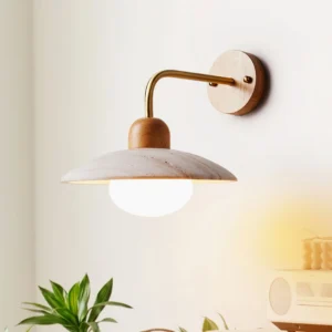 Brass and wood travertine wall lamp sconce positioned in home interior corner with green plant decor