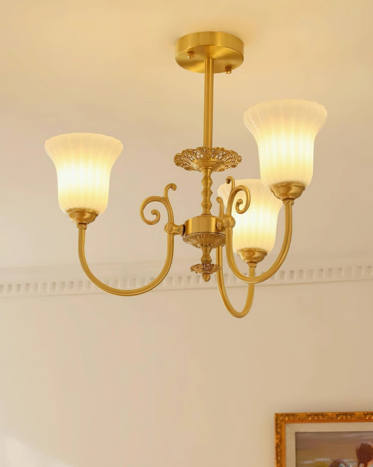Close-up detail of Caroline brass chandelier carved scrollwork and ribbed glass shade texture