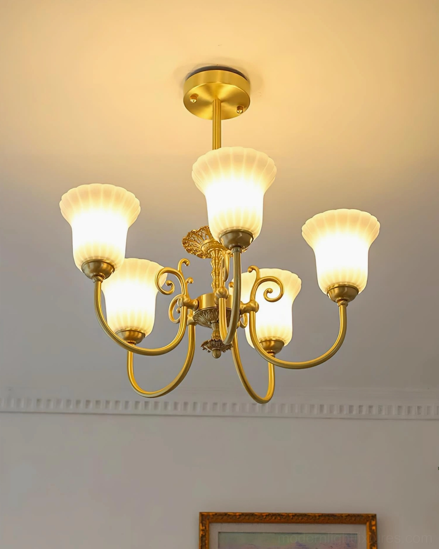 Caroline brass chandelier installed over dining room table creating elegant lighting focal point