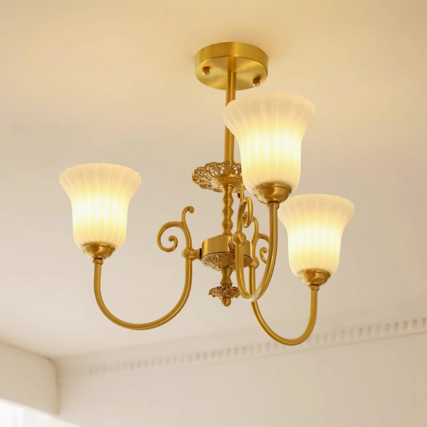 Interior installation of Caroline brass chandelier showing light diffusion through frosted glass