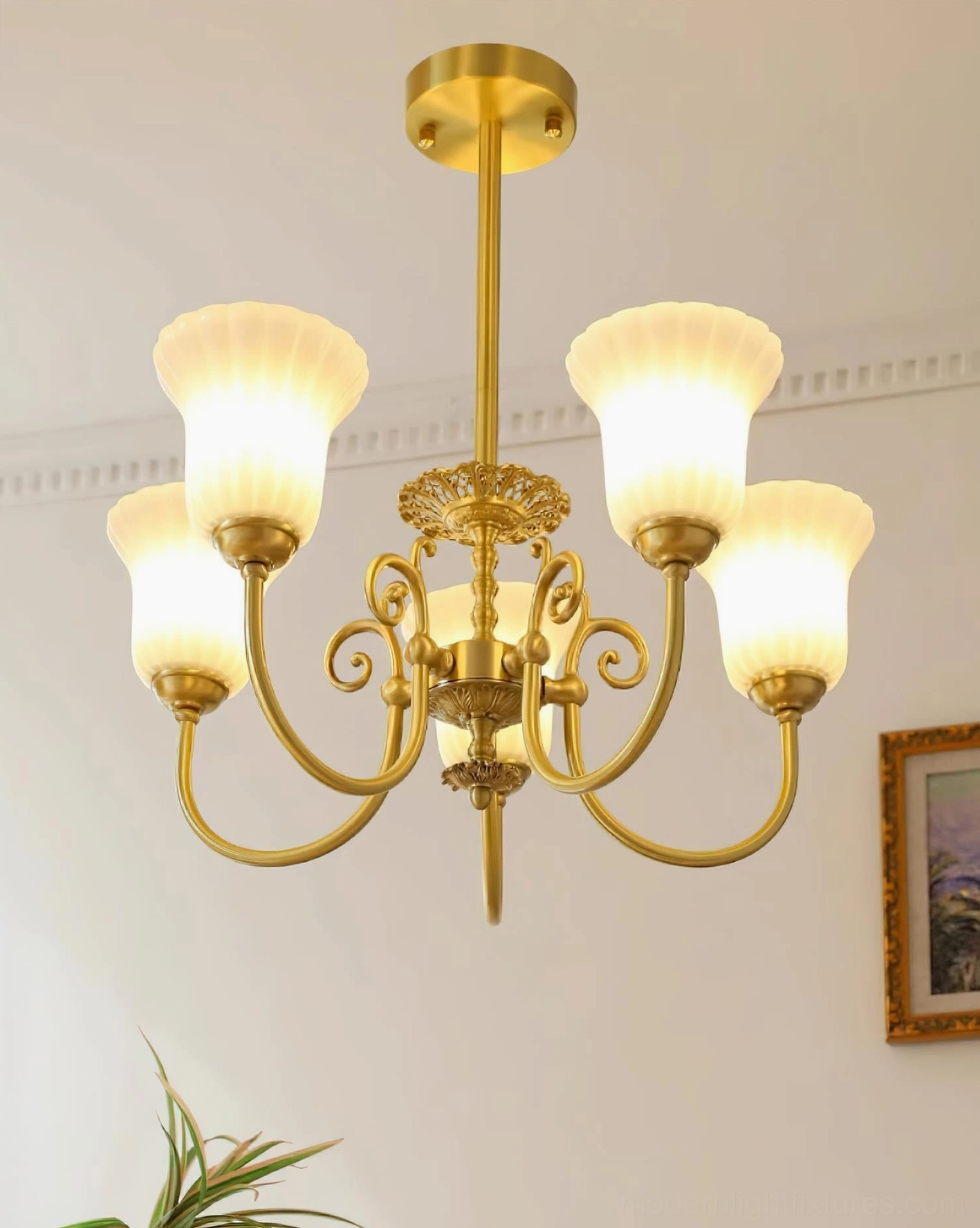Side view of 3-head brass chandelier with stacked white glass shades on curved arms