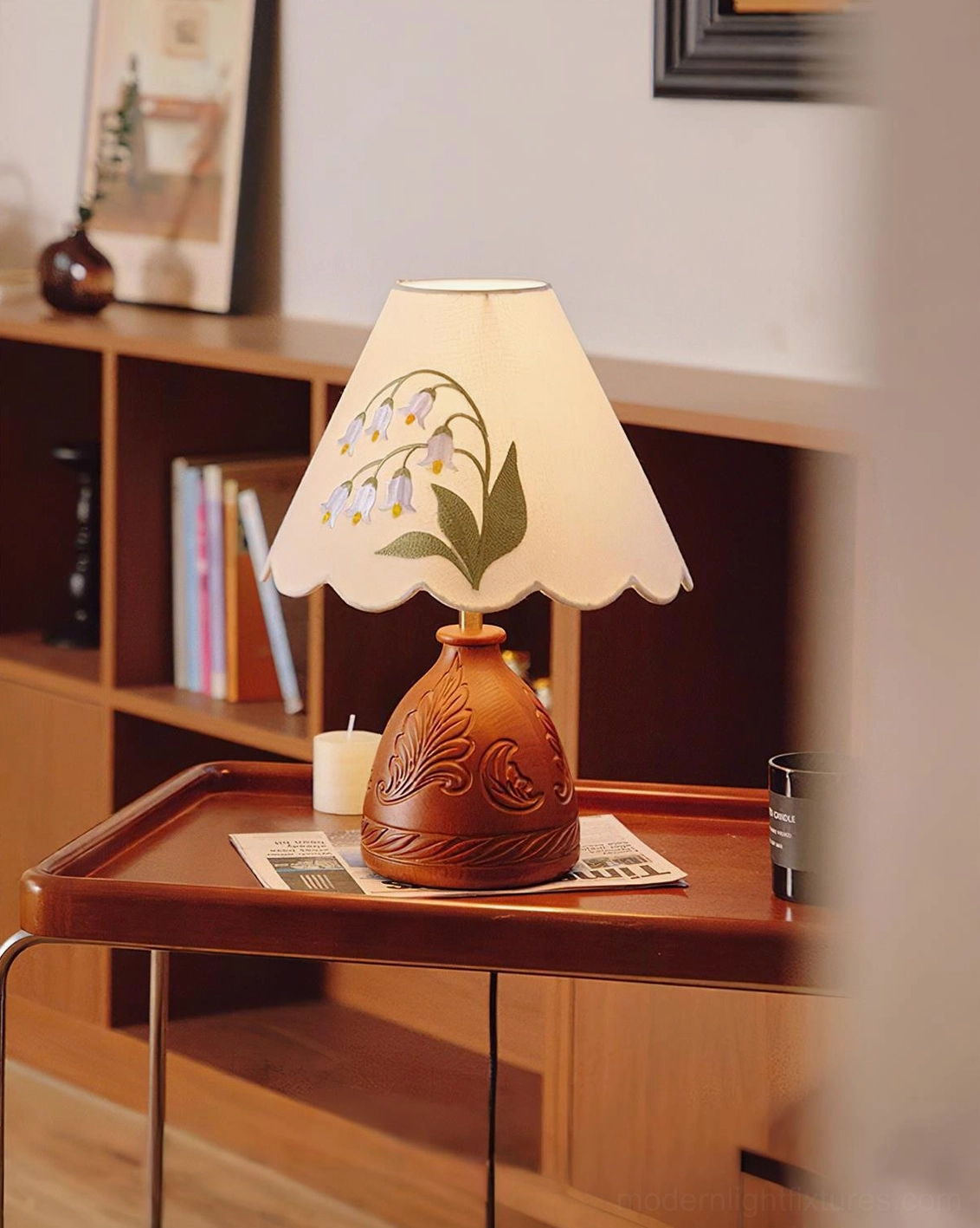 Handcrafted table lamp on study desk with bookshelf and vintage accessories
