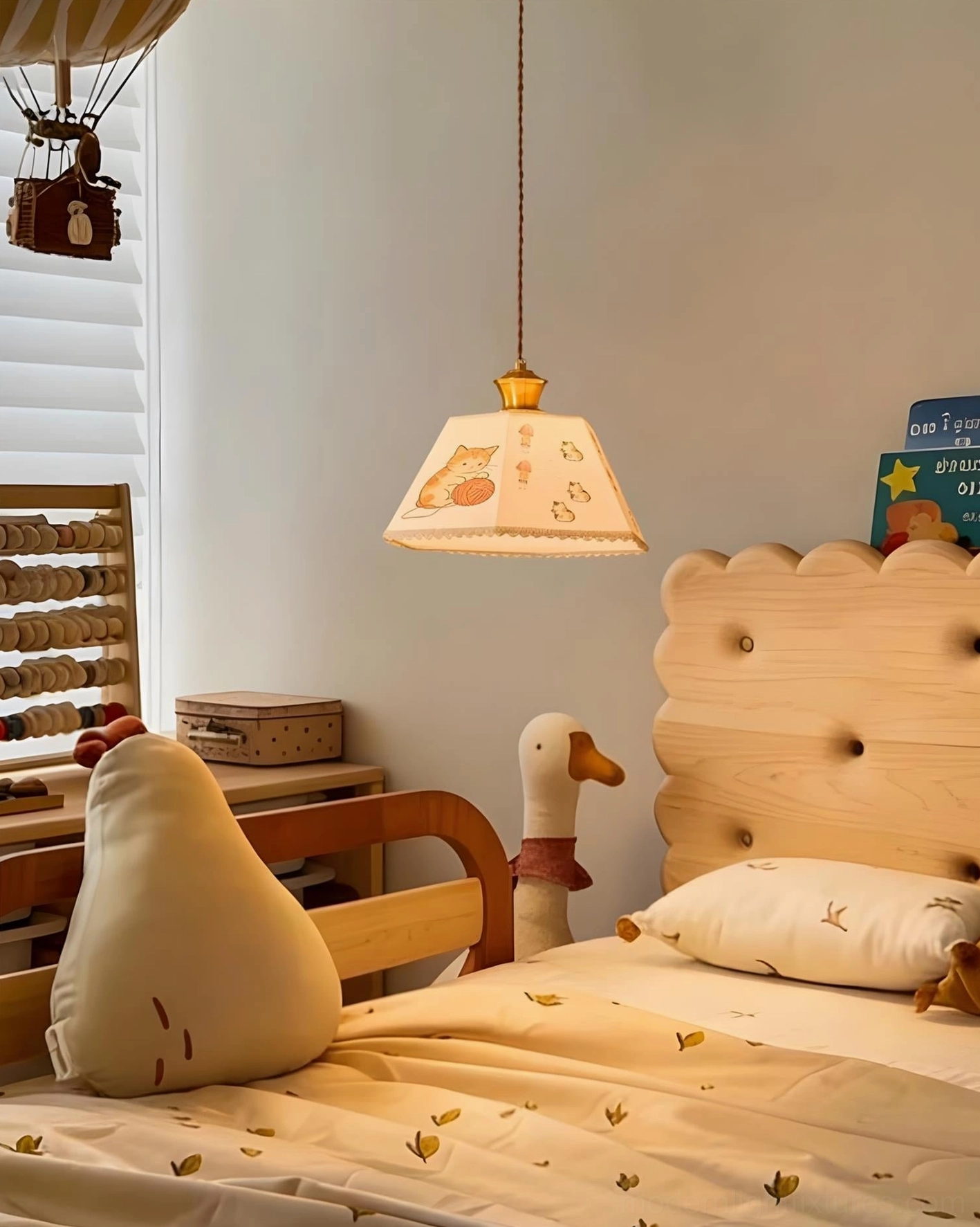 Whimsical cat print pendant light in cozy children's bedroom above tufted wooden bed