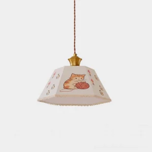 Whimsical cat print pendant light with hexagonal fabric shade and brass gold hardware, front studio view