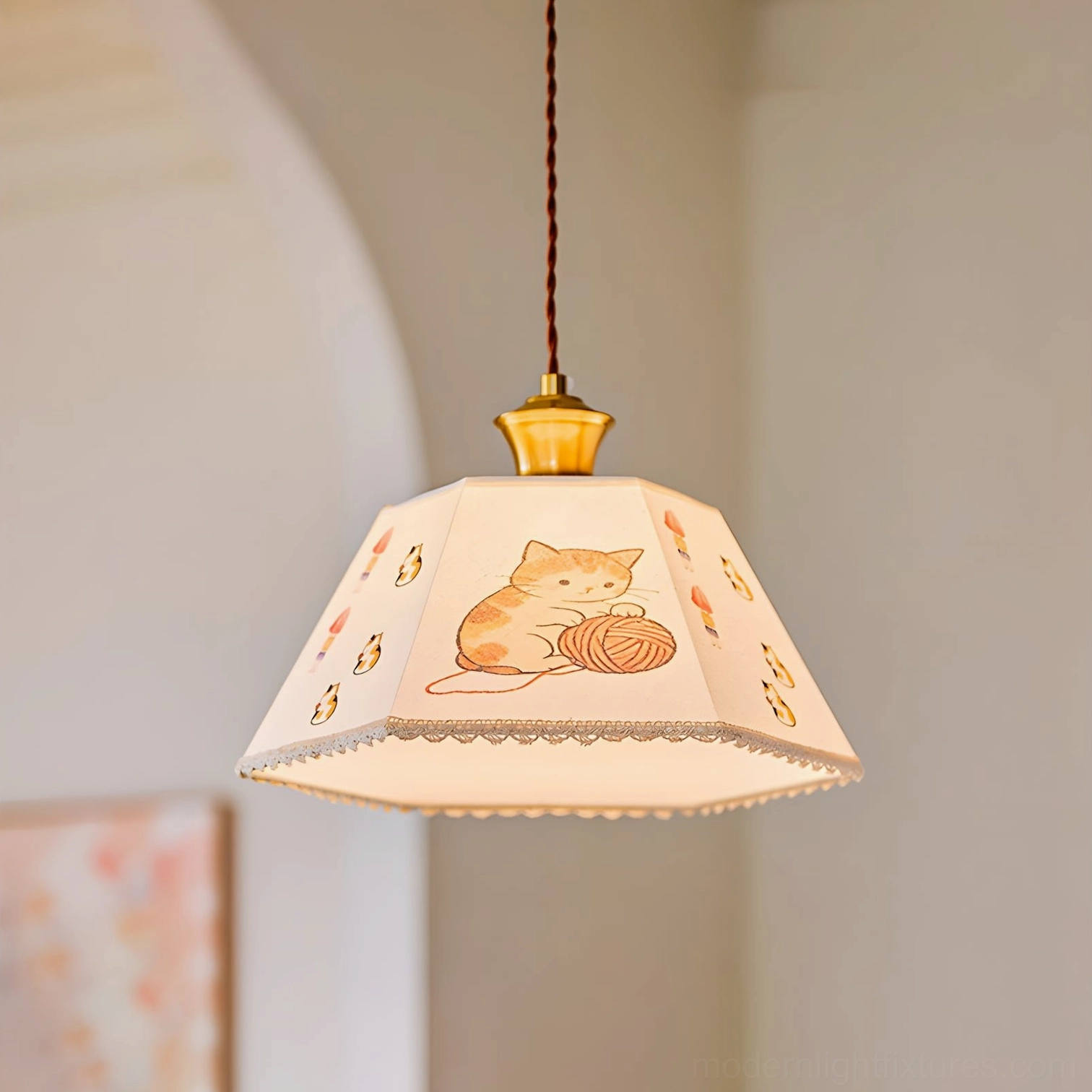 Close-up detailed view of illustrated cat and yarn print on fabric pendant shade with brass accents