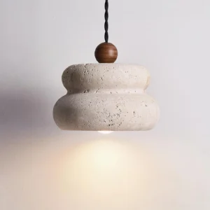 Overhead close-up detail of travertine stack pendant showing natural stone texture and twisted dark suspension cord with wooden bead accent