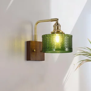 Cavella wall sconce installed in sunlit interior, three-quarter angle showing brass arm and walnut backplate detail
