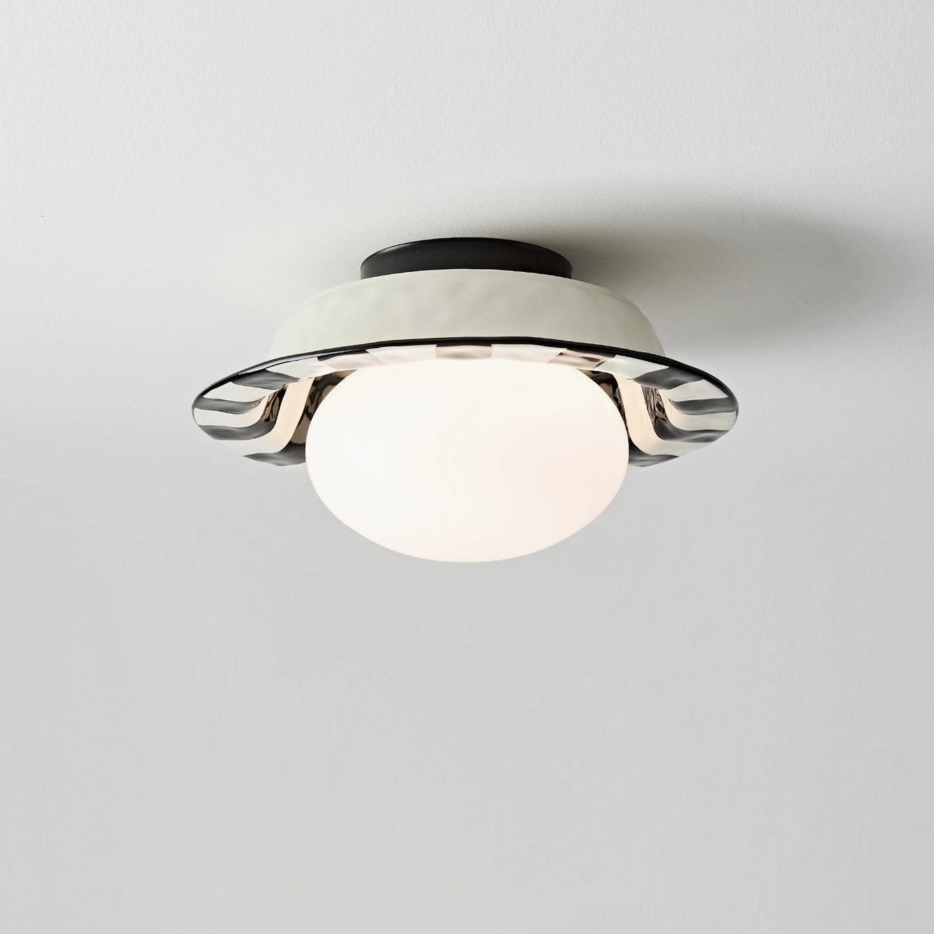 Close-up of illuminated checker ceiling lamp highlighting frosted glass diffuser and silver wavy metallic accent trim