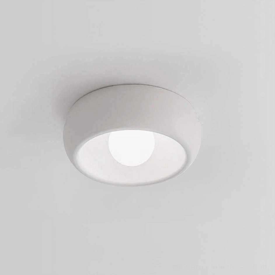 White finish circular ceiling light demonstrating neutral recessive aesthetic in minimalist interior