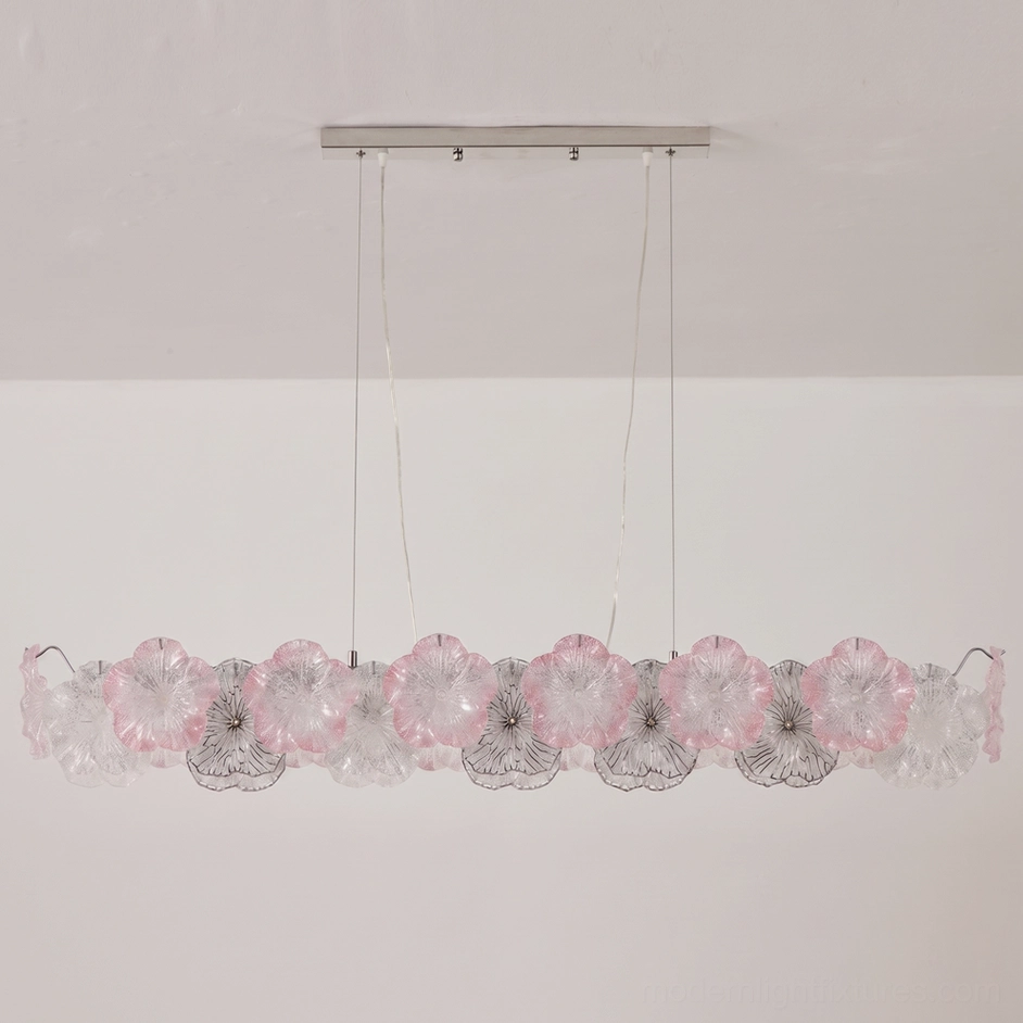 Celadine linear bar chandelier with blush pink and clear hand-formed glass petals installed above dining table with elegant plating