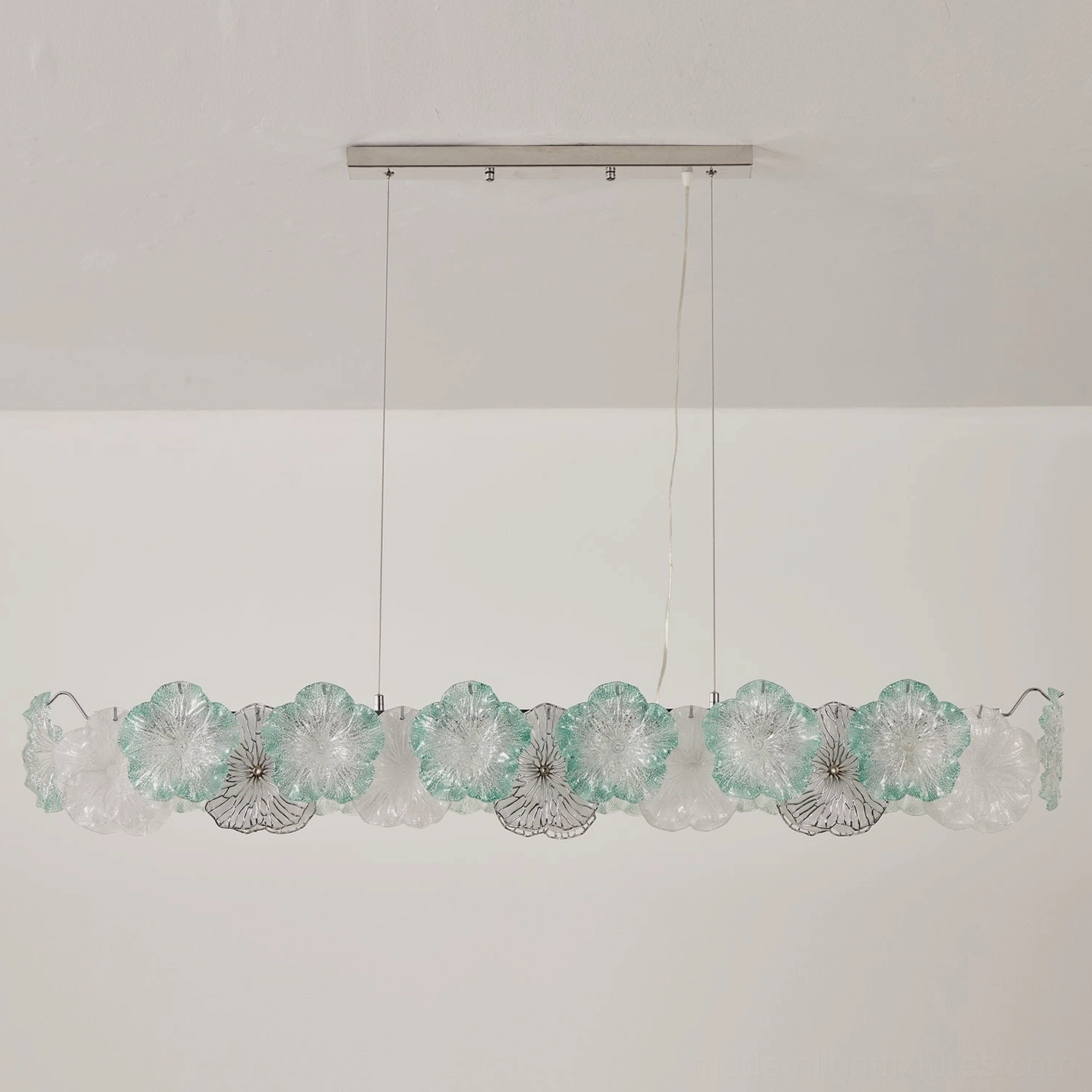 Celadine linear bar chandelier with seafoam green and clear hand-formed glass petals over kitchen island counter