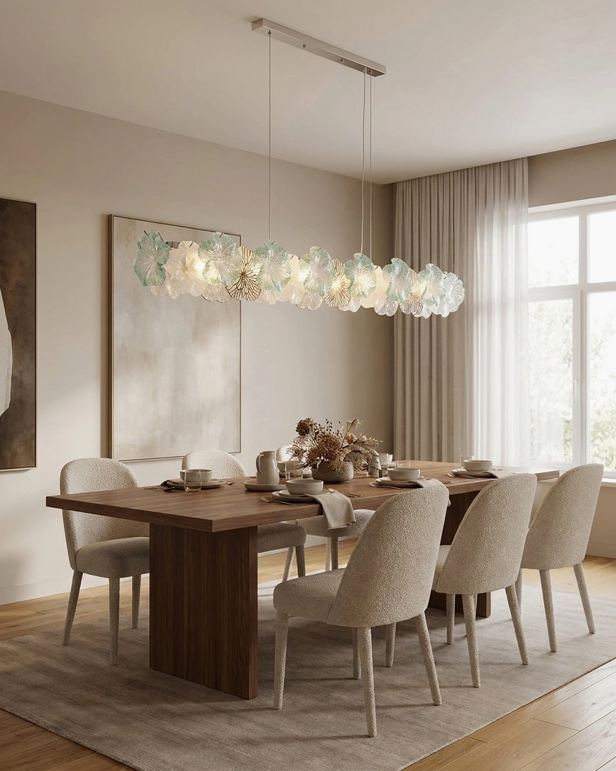 Linear translucent Celadine chandelier with frosted hand-formed glass petals above modern upscale dining table with dark wood and neutral fabric chairs