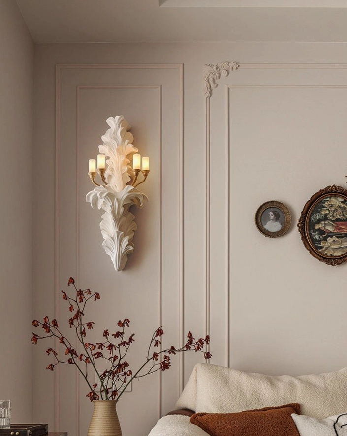 Celandra wall sconce in cozy classic living room setting, mounted on paneled wall with decorative artwork and dried florals, traditional interior