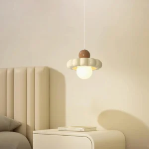 Celena pendant light hanging in cream bedroom with tufted headboard, side angle view
