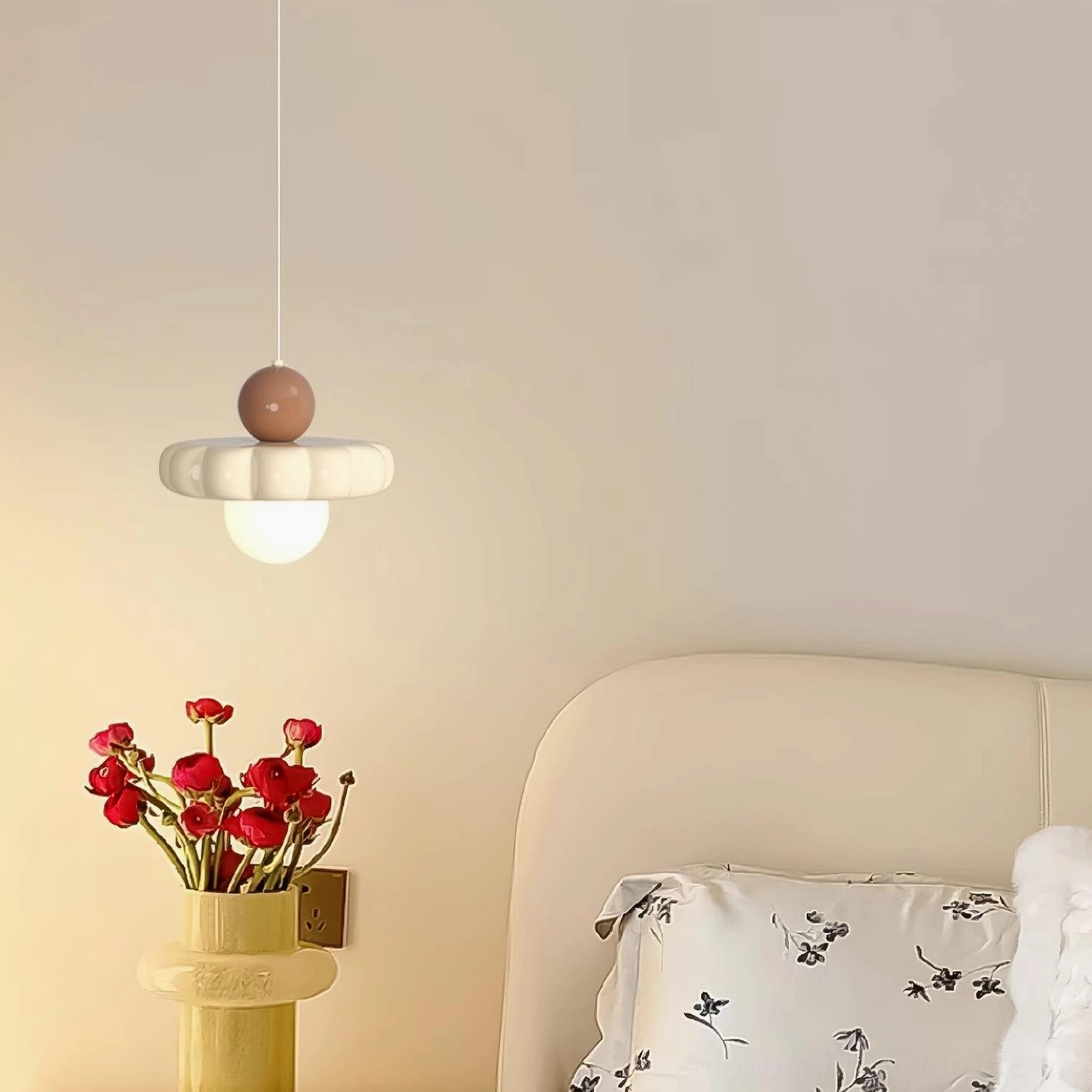 Celena pendant light with brown accent top ball in cream bedroom, side hanging perspective